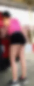 Girl showing her ass cheeks at her car in black shorts