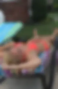 Sexy blonde lady in a bikini with a great body laying by the pool