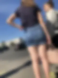 Cute Girl in a Short Denim Skirt Walking on a Street And Waiting on a Crosswalk Gallery