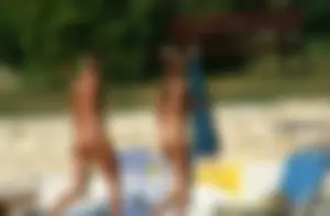Two sexy nude beach friends getting some sun
