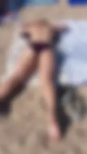 Hot girl laying on the beach in her purple bikini