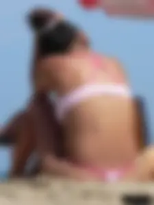 Hot brunette ethnic girl on the beach in a pink thong bikini