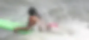 Brunette bikini girl on the beach and surfing in her bikini