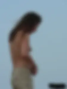 Sexy babe with a nice body topless and in a thong on the beach