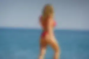 Hot blonde with a slammin body in red thong bikini on the beach