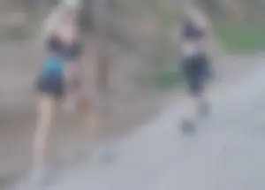 Girls in tight clothes walking down a dusty road