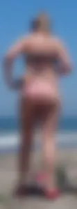 Chunky beach blonde babe in a pink thong bikini