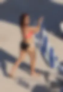 Sexy red haired girl in pink and black bikini at the pool