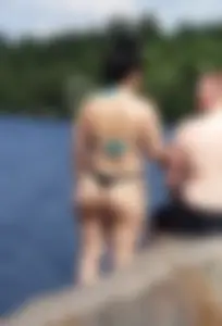 Thick brunette at the lake in a black thong bikini