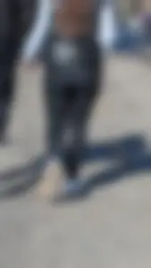 A beautiful little brunette walking in the park. tight black leggings