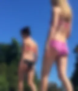 Couple of sexy teen friends laying out in bikinis