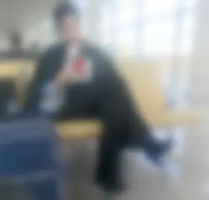 Girl in Pants And High-Heeled Shoes Sitting at the Station With Crossed Legs