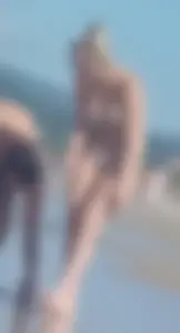 Smooth bodied and sexy blonde at the beach in a thong bikini