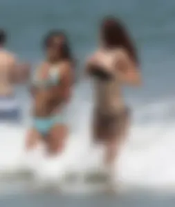 Brunette and redhead on the beach in bikinis looking sexy
