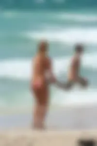 Topless girl in a tiny thong on the beach playing paddle ball