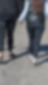 A beautiful little brunette walking in the park. tight black leggings