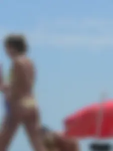 Sexy blonde on the beach in a yellow thong bikini