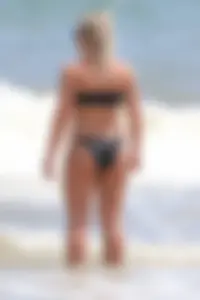 Beach blonde in the water in black bikini with a nice ass and small boobs