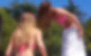 Sexy blonde up close in pink bikini with friend