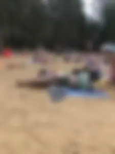Cute Candid Girl in a Green Swimsuit With Pale Skin Lying on the Beach