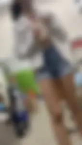 Tight bum hanging out of jean shorts in thrift shop