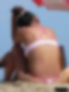 Hot brunette ethnic girl on the beach in a pink thong bikini