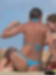 Sexy lady on the beach in a blue thong bikini