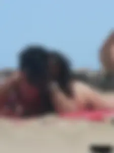 Brunette lady topless and in a black thong on the beach