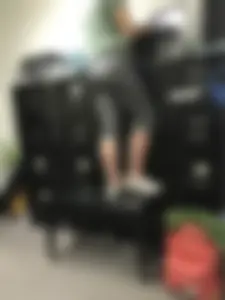 Girl in short grey tights standing on a bench by filing cabinets