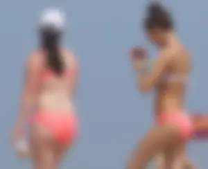 Two sexy girls in peach and pink bikinis on the beach