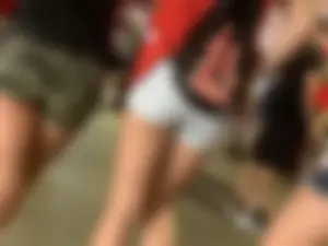 Bunch of girls in various outfits at a Cardinals baseball game