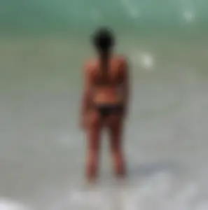 Black girl on the beach in a bikini with an incredible ass while surfing
