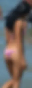 Little brunette ass in a pink bikini at the beach