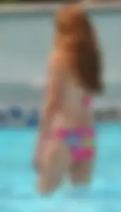 Skinny ginger in pink floral bikini in the pool