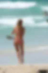 Topless girl in a tiny thong on the beach playing paddle ball