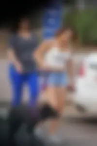 Sexy dog walker in shorts and tank top with friend in blue jeans