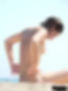 Topless beach milf looking sexy in a tiny g-string bikini