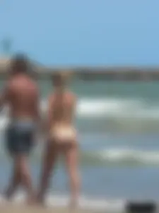 Sexy blonde on the beach in a yellow thong bikini