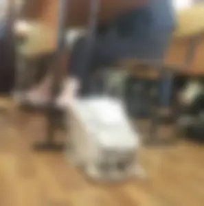 College Girl’s Crossed Legs in Striped Pants Under Desk Closeup in Classroom
