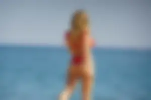 Hot blonde with a slammin body in red thong bikini on the beach