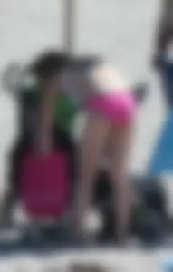 Skinny blonde girl on the beach in her pink and white bikini