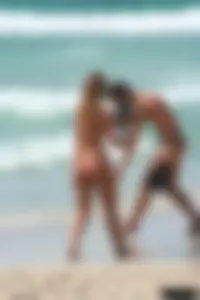 Topless girl in a tiny thong on the beach playing paddle ball