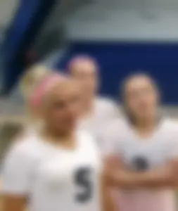 Bunch of cute college girls in bright pink shorts playing volleyball