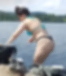 Thick brunette at the lake in a black thong bikini