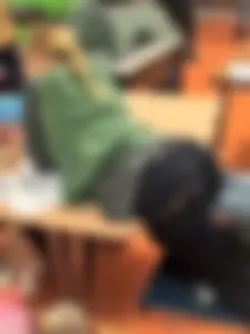 College teen in tight jeans bending over desk