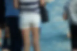 Hot Tanned Legs in White Denim Shorts on the Beach Closeup Photos