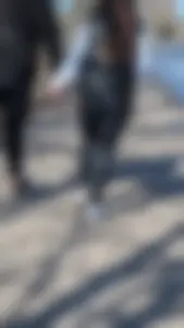 A beautiful little brunette walking in the park. tight black leggings