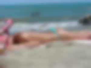 Hot ass blonde babe on the beach topless and in a little thong with a great ass
