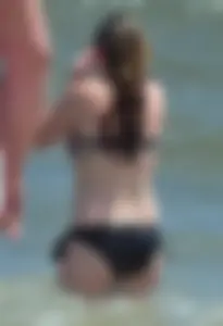 Cute beach girl in little bikini in the water
