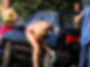 Group of cute girls at a car wash in bikinis and shorts